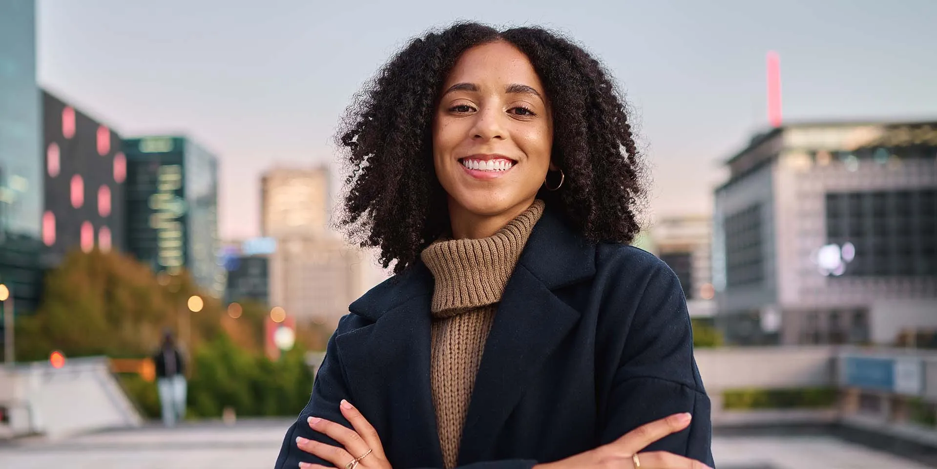 A confident professional standing with arms crossed